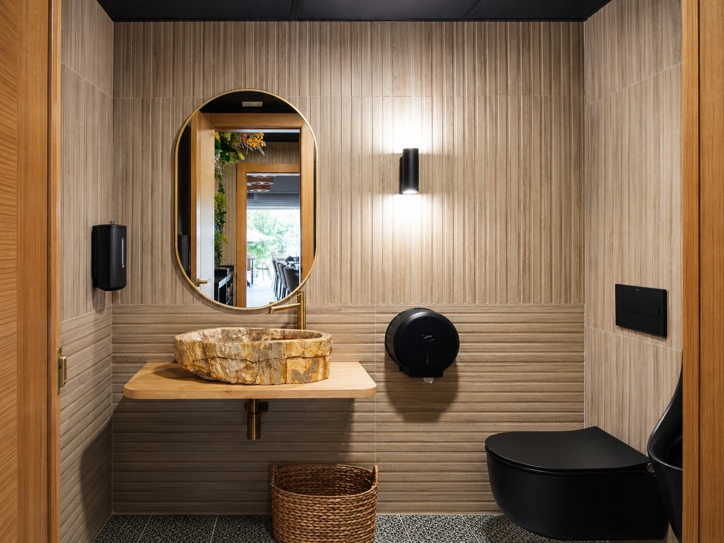 Aseo del restaurante Los Dos en El Campello con espejo circular de madera y lavabo sobre encimera