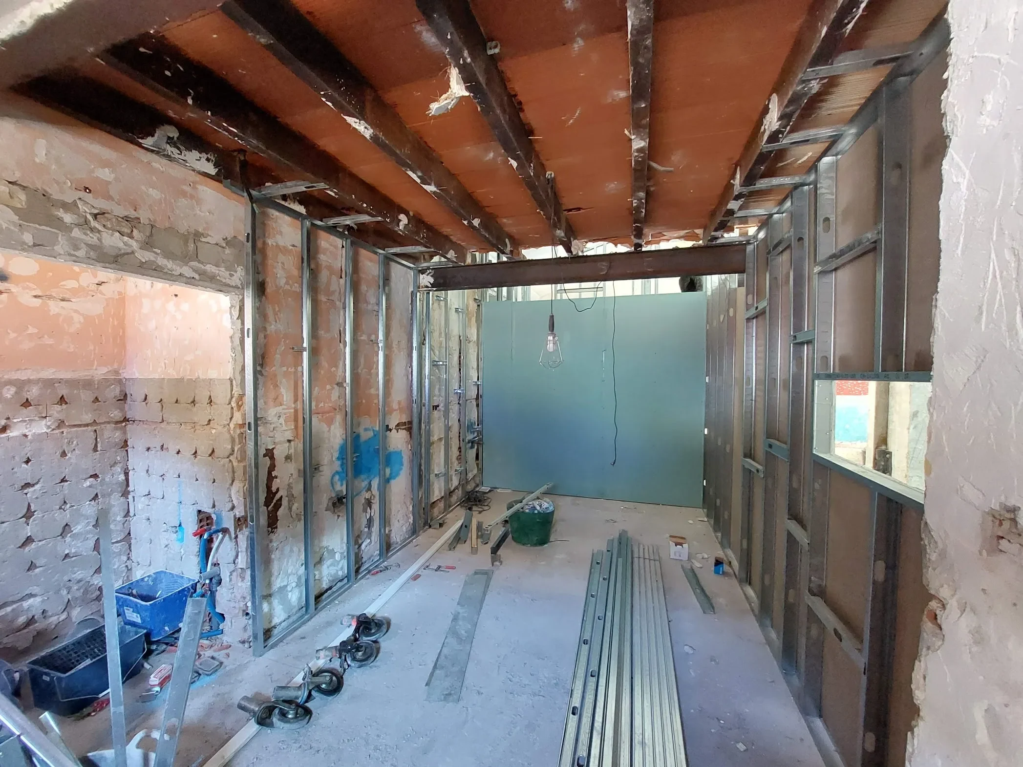Cocina del restaurante Los Dos en El Campello en fase de obra, con estructura metálica para tabiques y vigas de madera al descubierto