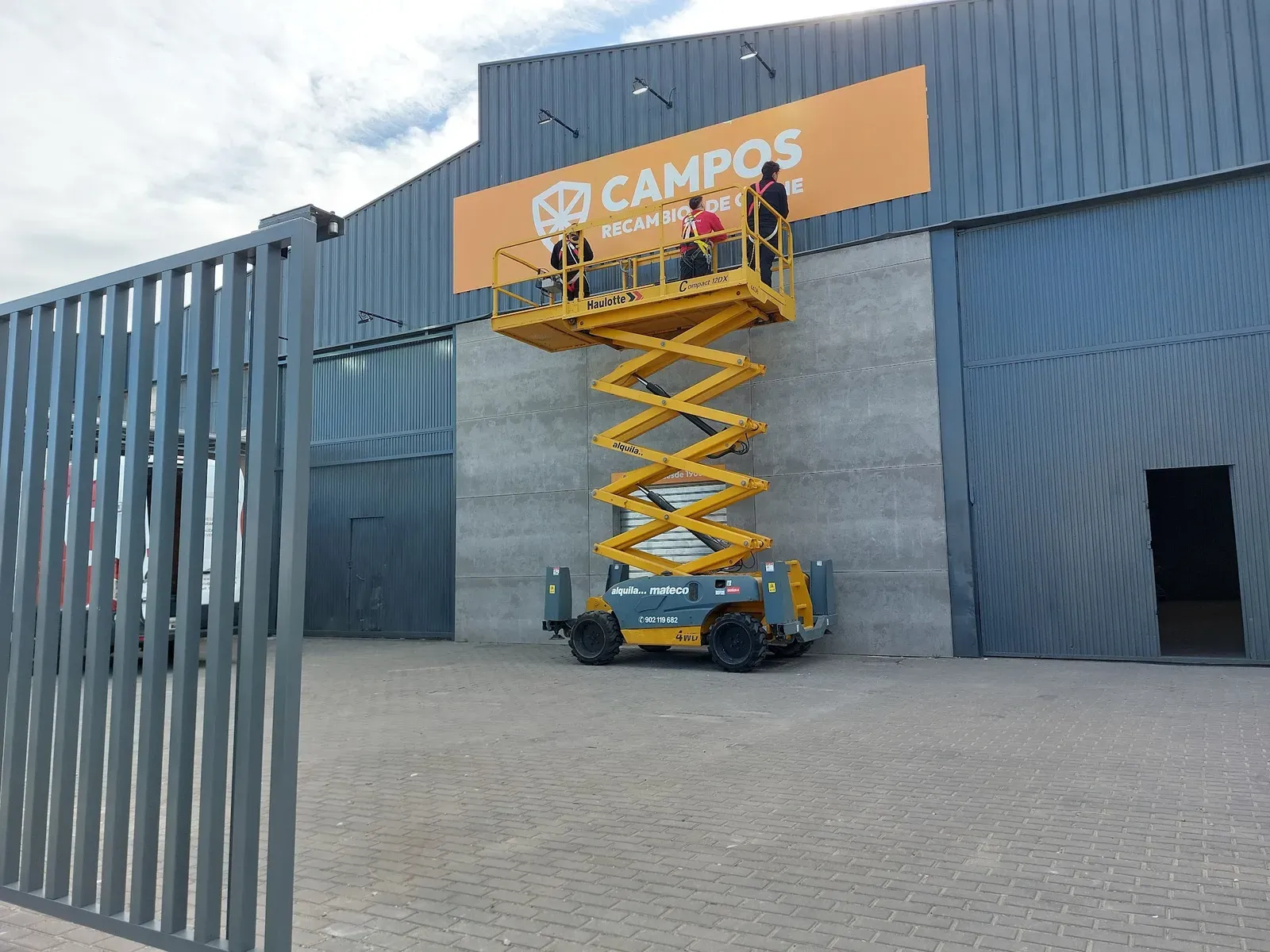 Instalación de un rótulo de gran formato en la fachada de una nave de Alicante mediante plataforma elevadora