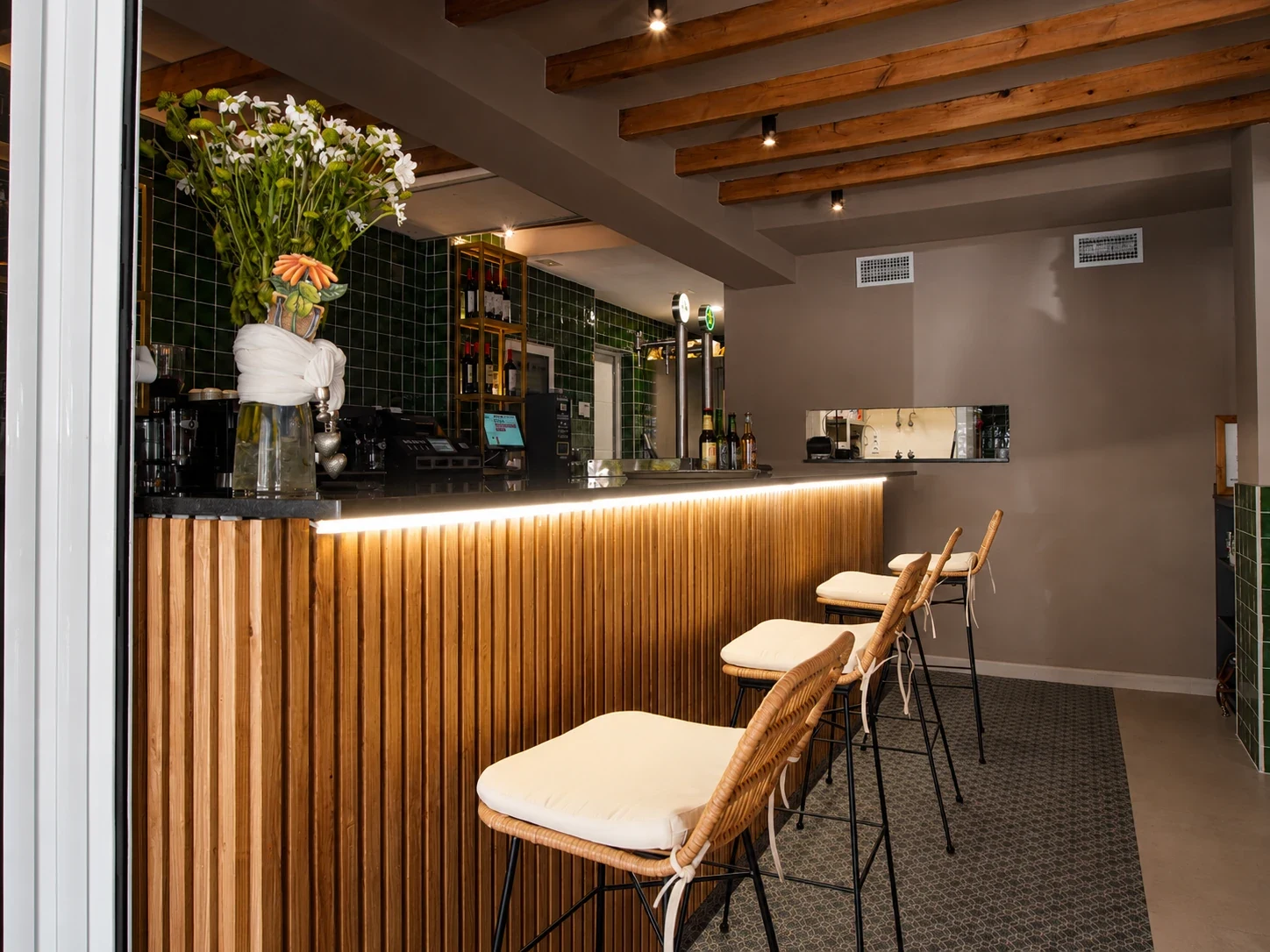 Interior del restaurante Los Dos en El Campello con techo de vigas de madera, taburetes altos y barra